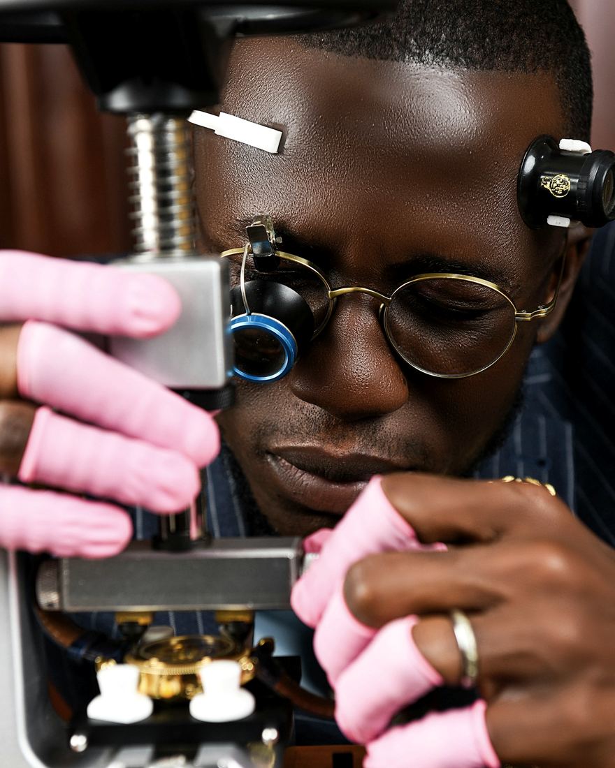 A watchmaker working down a microscope